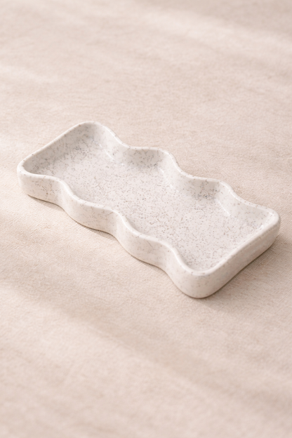 bandeja decorativa de cerámica blanca sobre mesa neutra