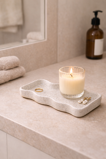 bandeja de cerámica blanca con vela en ambiente de baño relajante