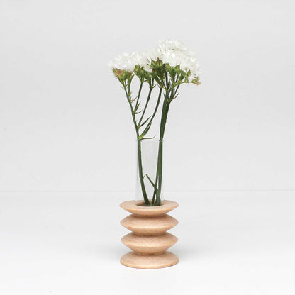 jarrón de madera con flores en diseño minimalista sobre fondo claro